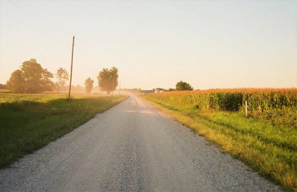 Road cutting through seemingly endless Indiana corn fields