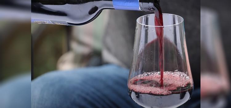 pouring red wine on a glass