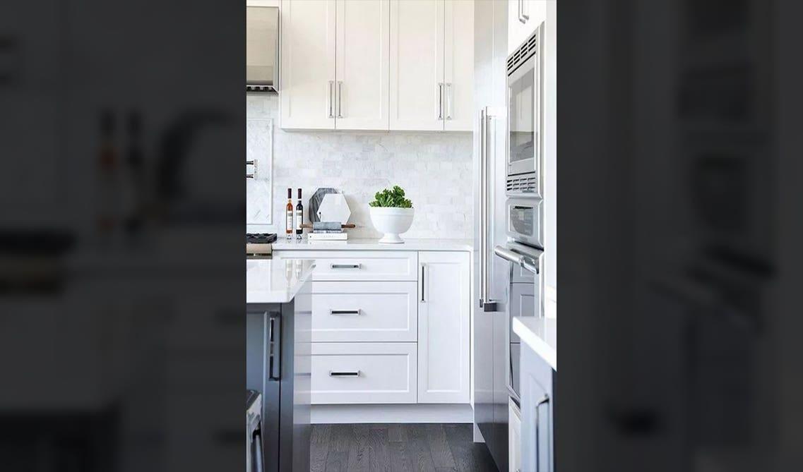 glossier square-edged metal pull in a silver on white cabinets