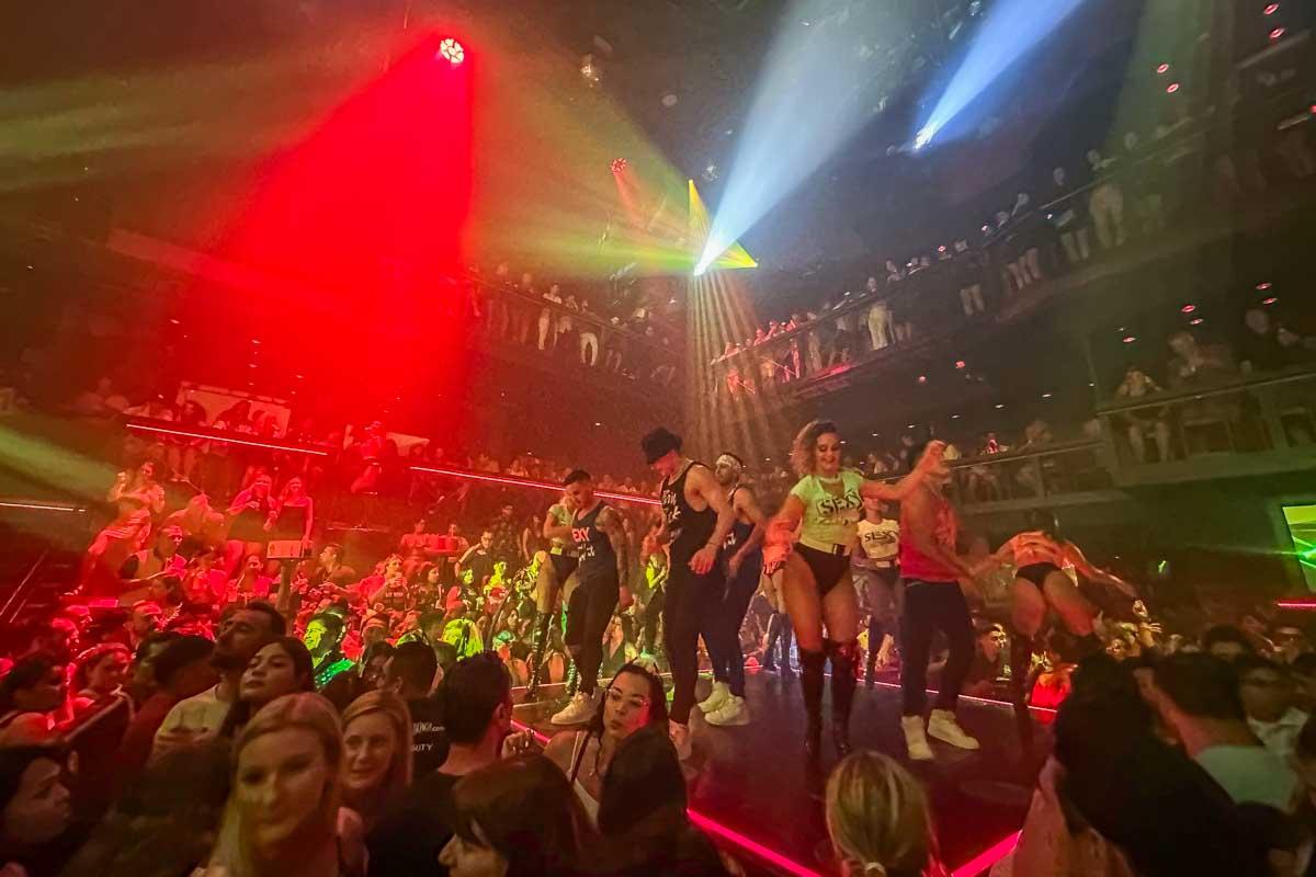 Dancers dance in the crowd at Coco Bongo on a raised stage