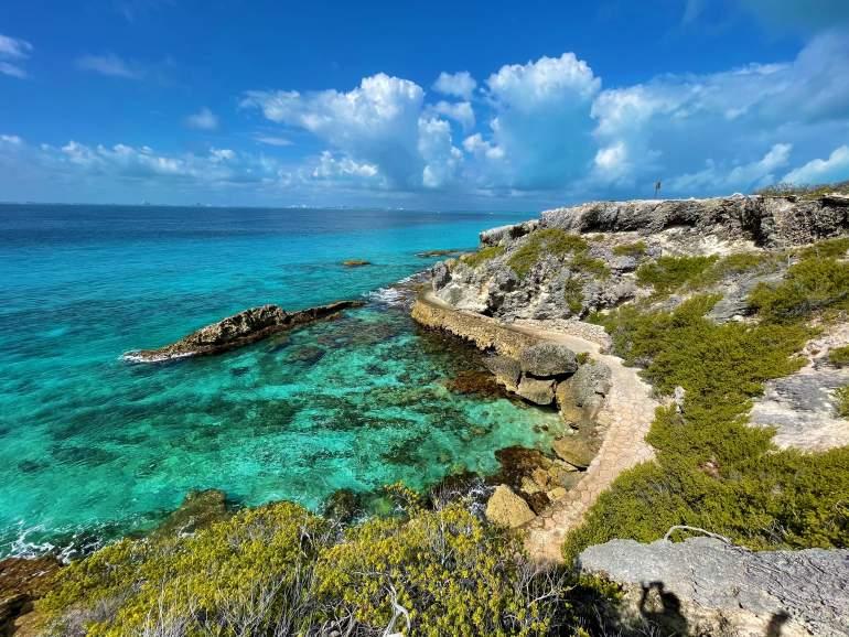 A view of the blue water and rocky shore at Isla Mujeres.