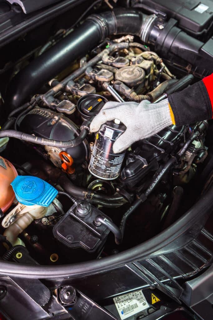 Mechanic removing a Mahle OX 388D oil filter from an Audi A3