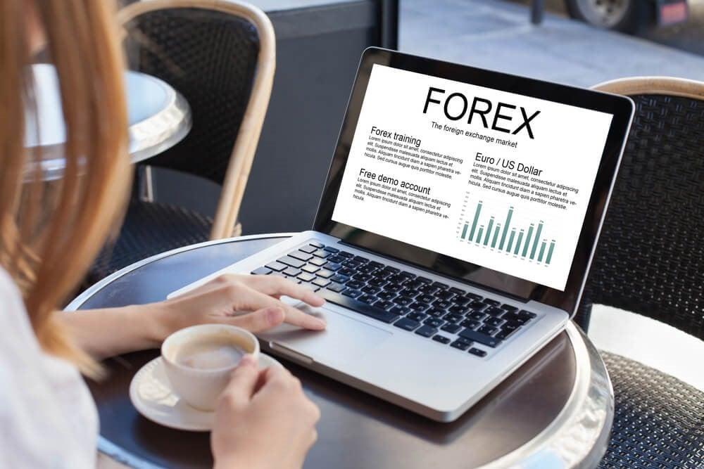 A person studying forex with a table, coffee and laptop - Finance brokerage