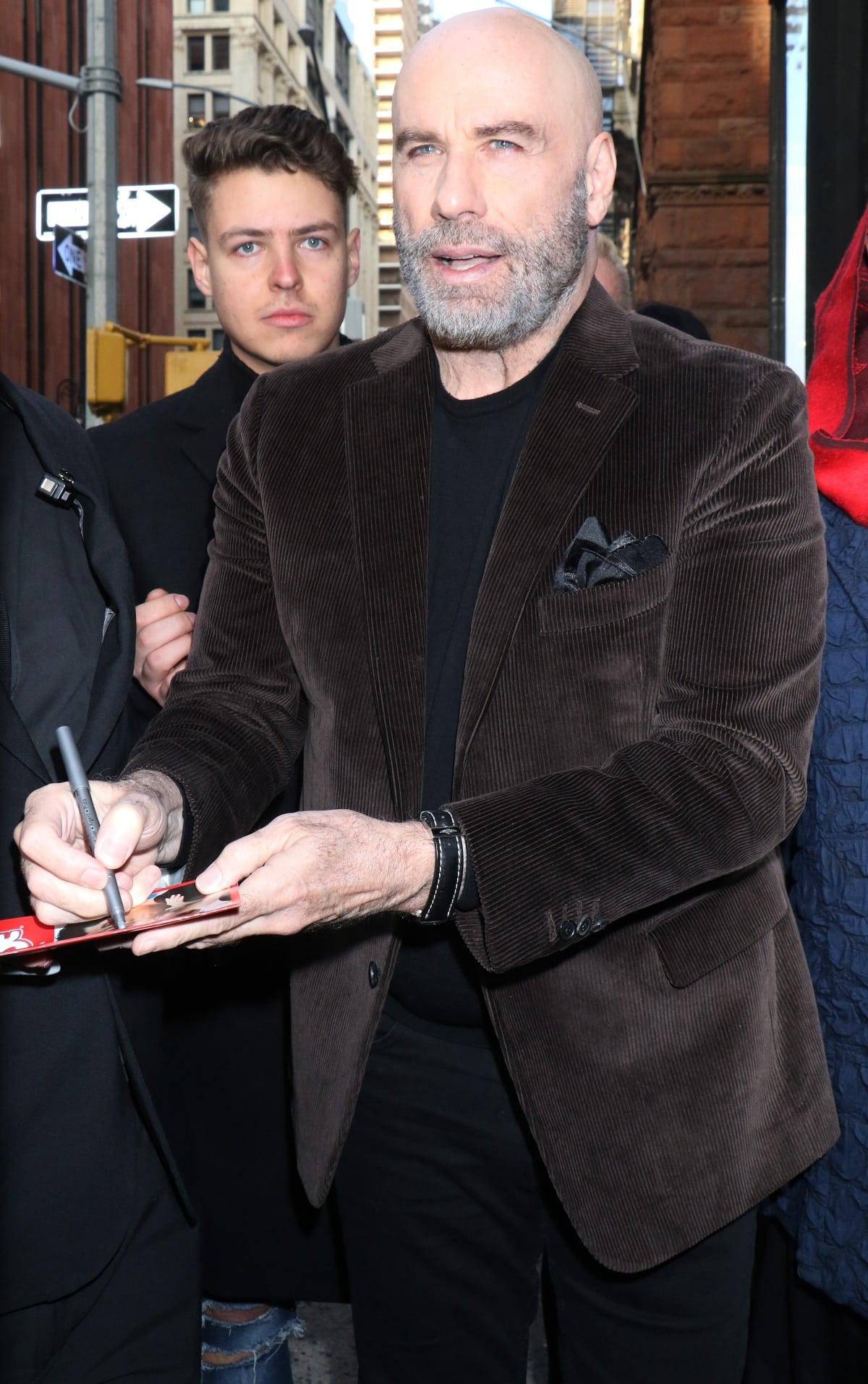John Travolta signing autographs outside the Build Series studios in New York City