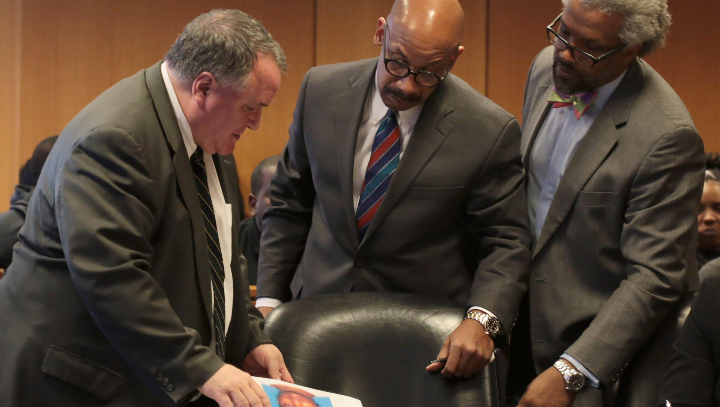 L-R Assistant Wayne County Prosecutor showing exhibit photos to defense attorneys, Marlon Blake Evans and Todd Perkins during preliminary examination for two men Dietrick Odums and Ottis Davis accused of killing rapper Dex Osama AKA(Byron Cox) at Frank Murphy Hall of Justice in Detroit on Friday, Oct. 23, 2015.