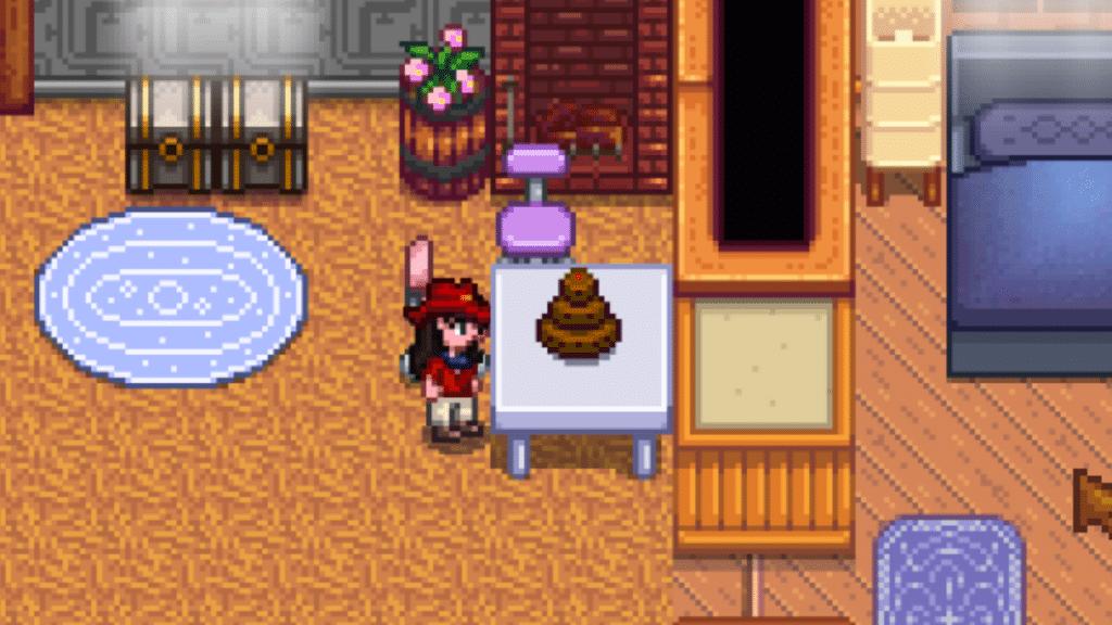 A player looking at a chocolate cake on a table in Stardew Valley.