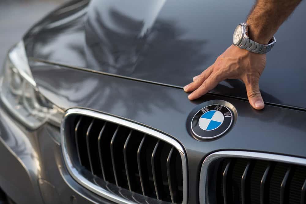 BMW sign close up with a man hand