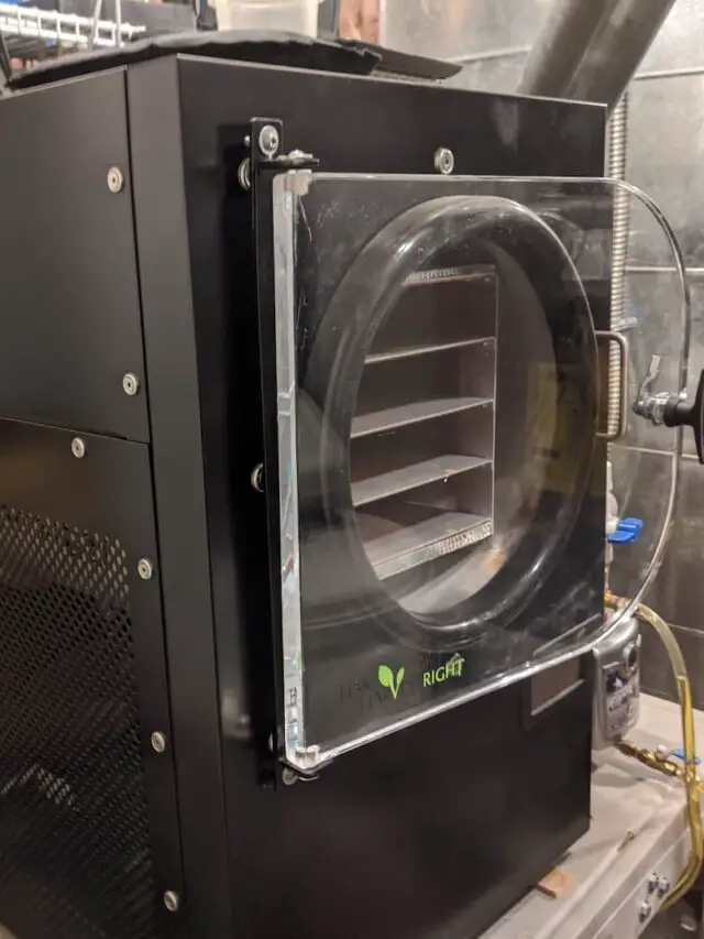 An image of a medium-sized black Harvest Right freeze dryer on a cart in a utility room