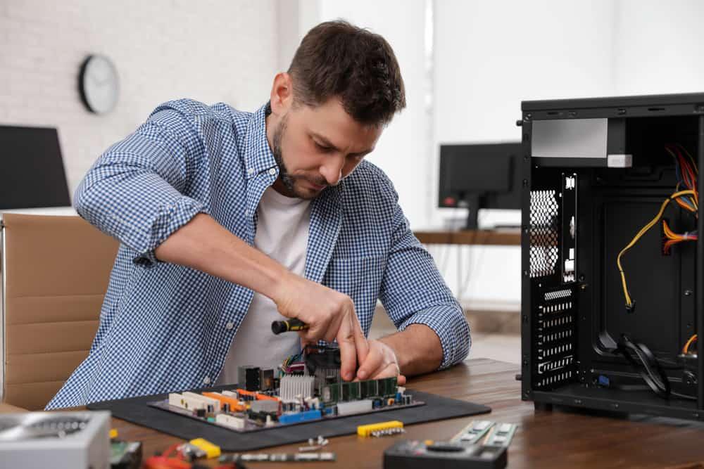 Male technician repairing motherboard