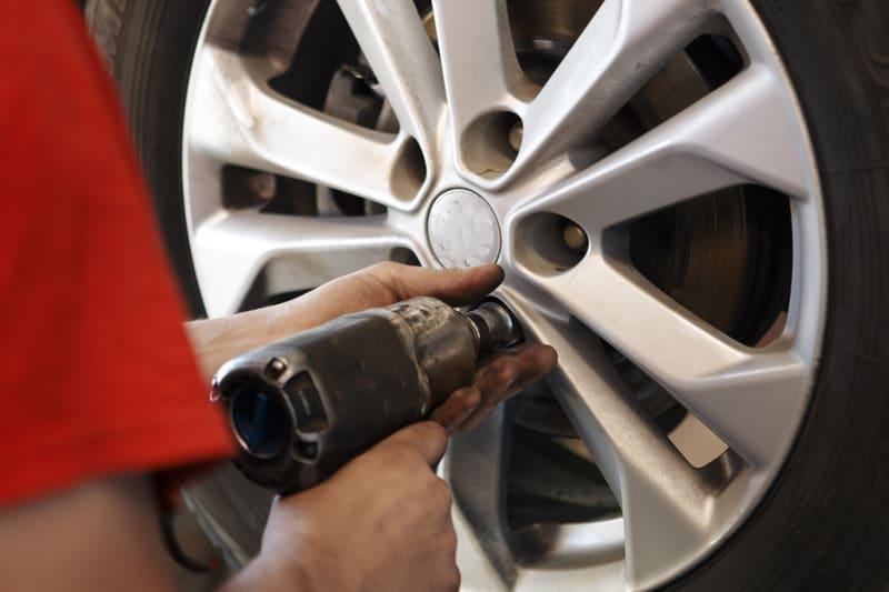 Mechanic removing the lug nuts from a car wheel
