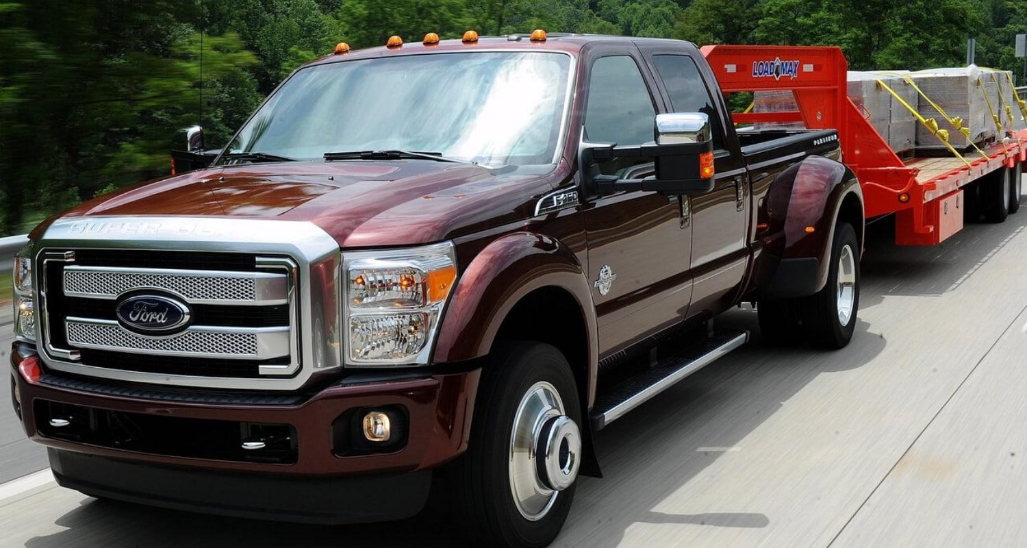 Used Ford Super Duty dually towing a very heavy load on a large trailer