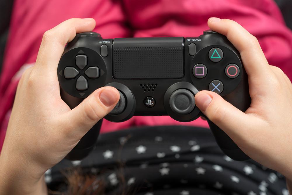 Hand girl playing Sony Dualshock 4 controller for PlayStation 4 pro