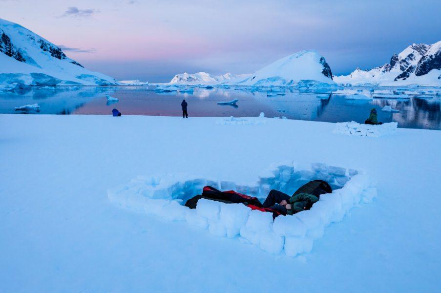 Two people in bivvy bags sleeping in Antarctica