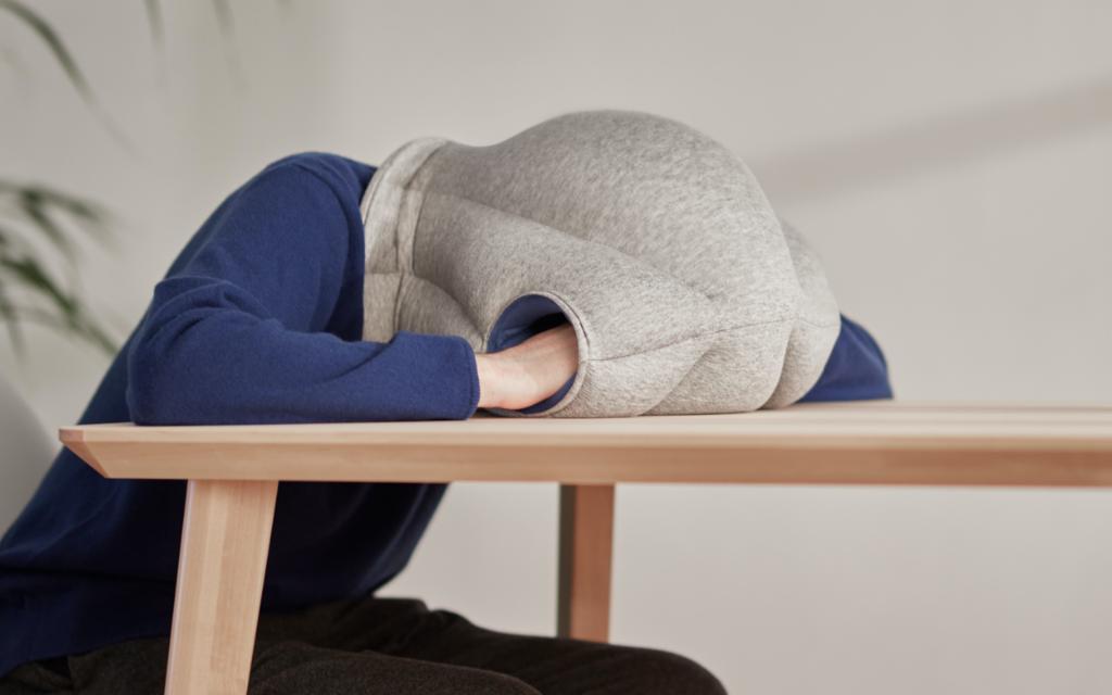 Man wearing Original Napping Pillow by Ostrichpillow