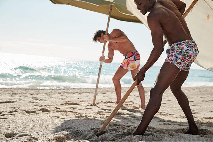 friends staking umbrellas at beach