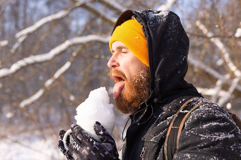 man eating snow