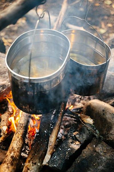 boiling water over campfire