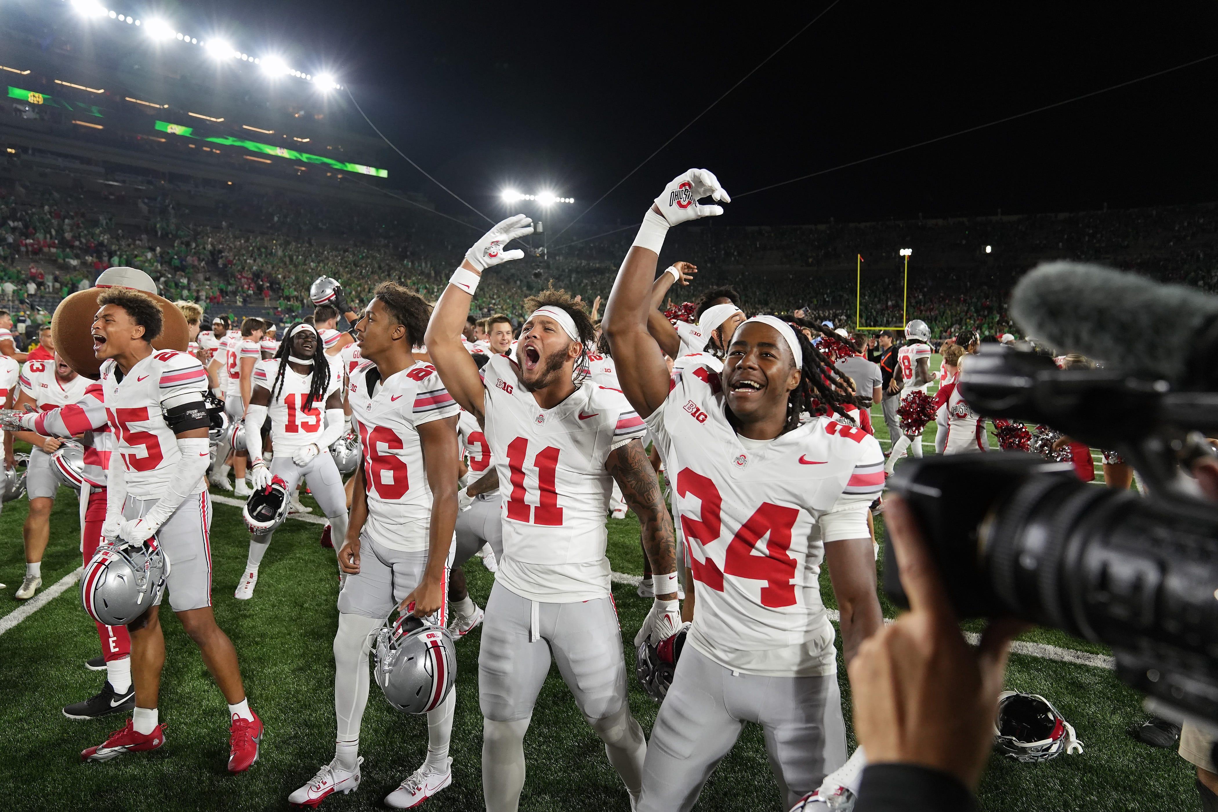 Ohio State Bryson Rodgers (86), Brandon Inniss (11) and Jermaine Mathews Jr. (24) celebrate after beating Notre Dame.