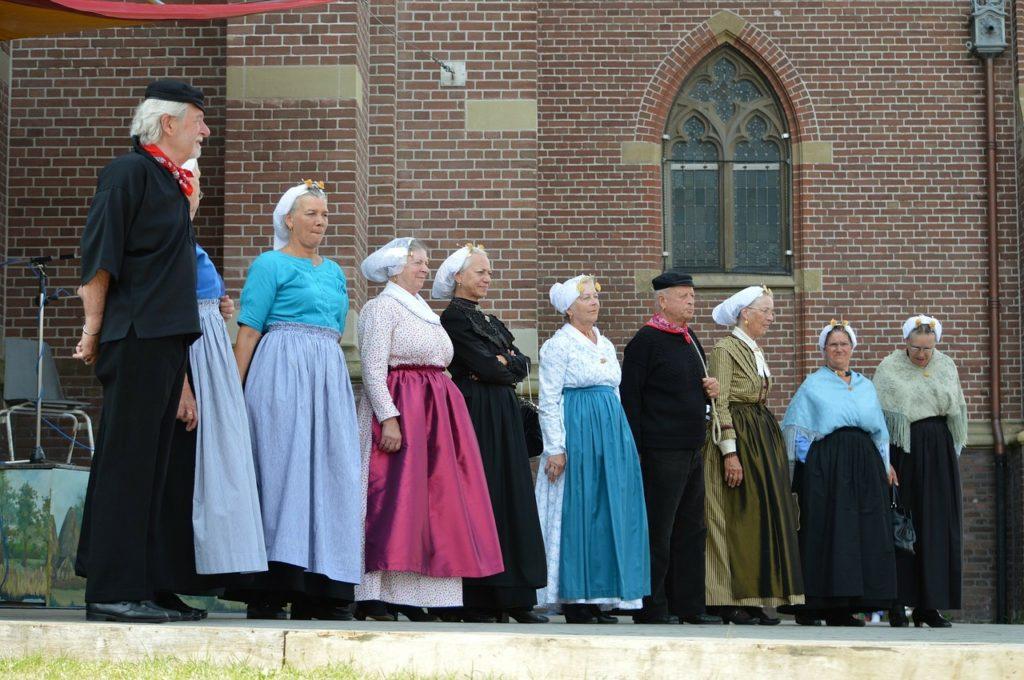 Group dressed in traditional dutch costumes in front of a church