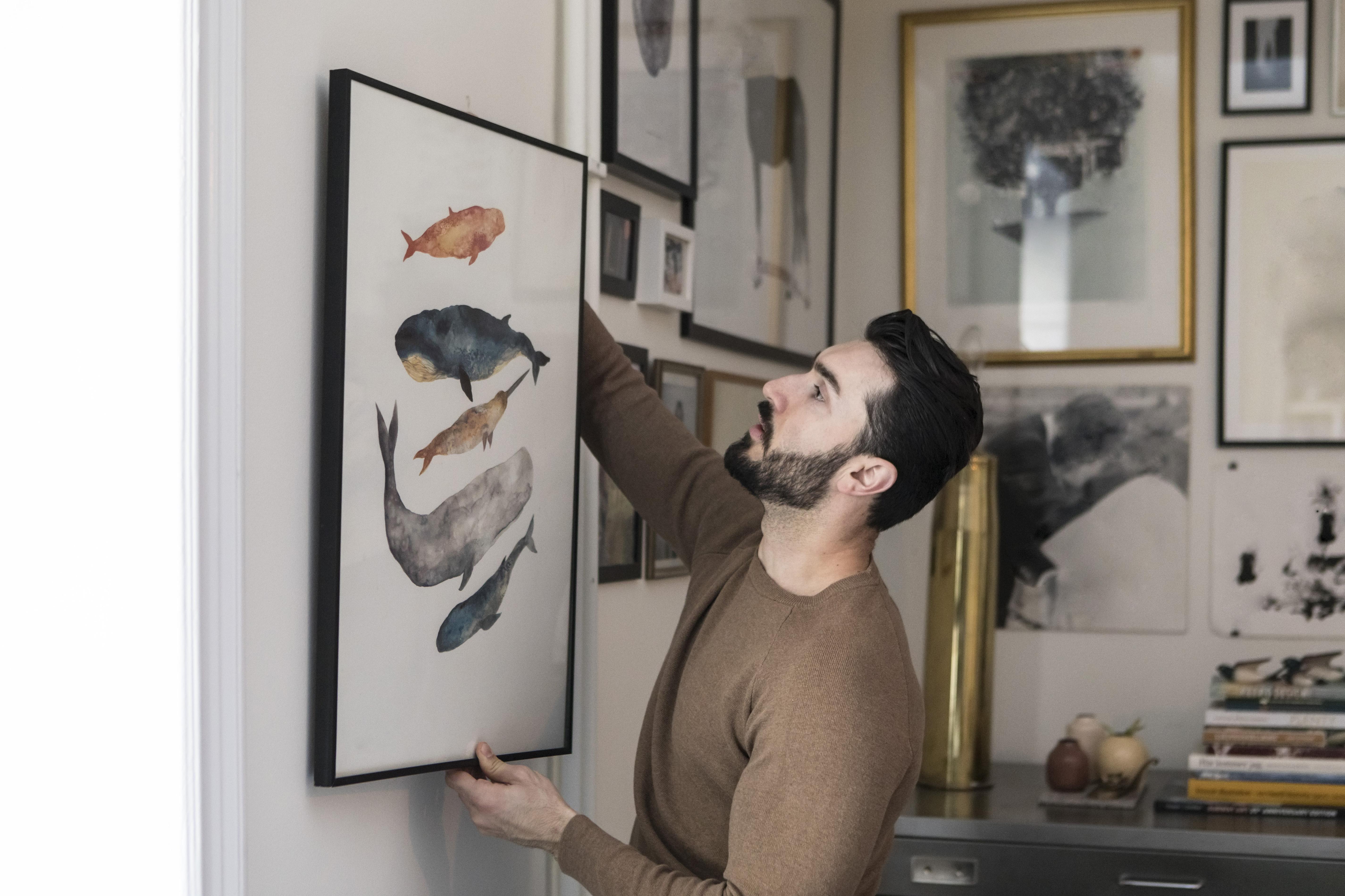 A man putting up a frame.