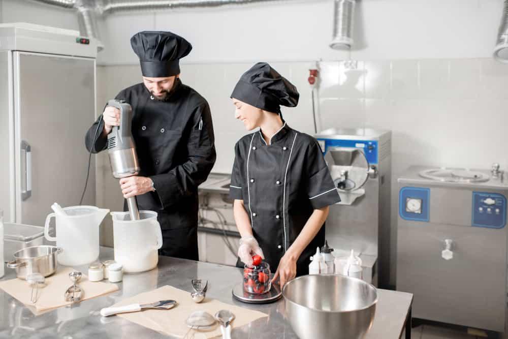 Chefs mixing berries with milk and sugar for ice cream production in the small ice cream manufacturing