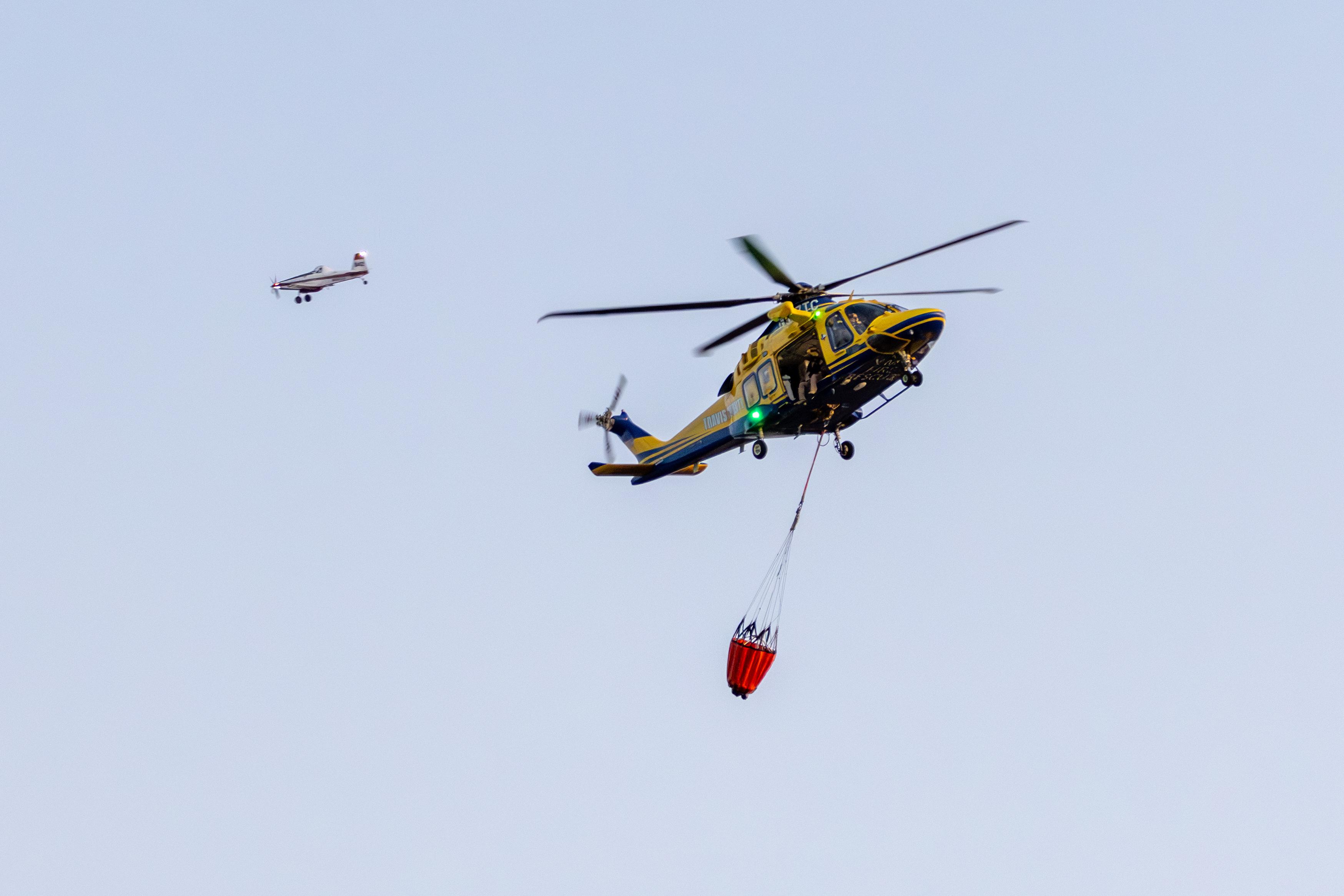 A helicopter drops water on the Parmer Lane Fire in Cedar Park on Aug. 8, 2023. (Courtesy Andrew Binkard)