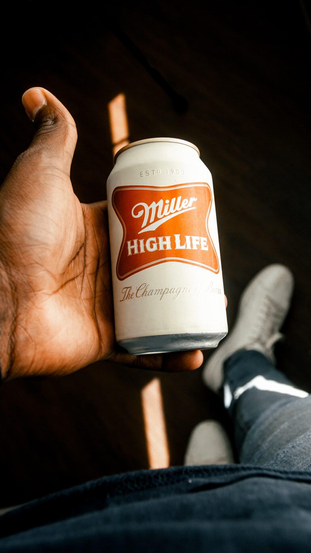 can of miller high life beer in hand