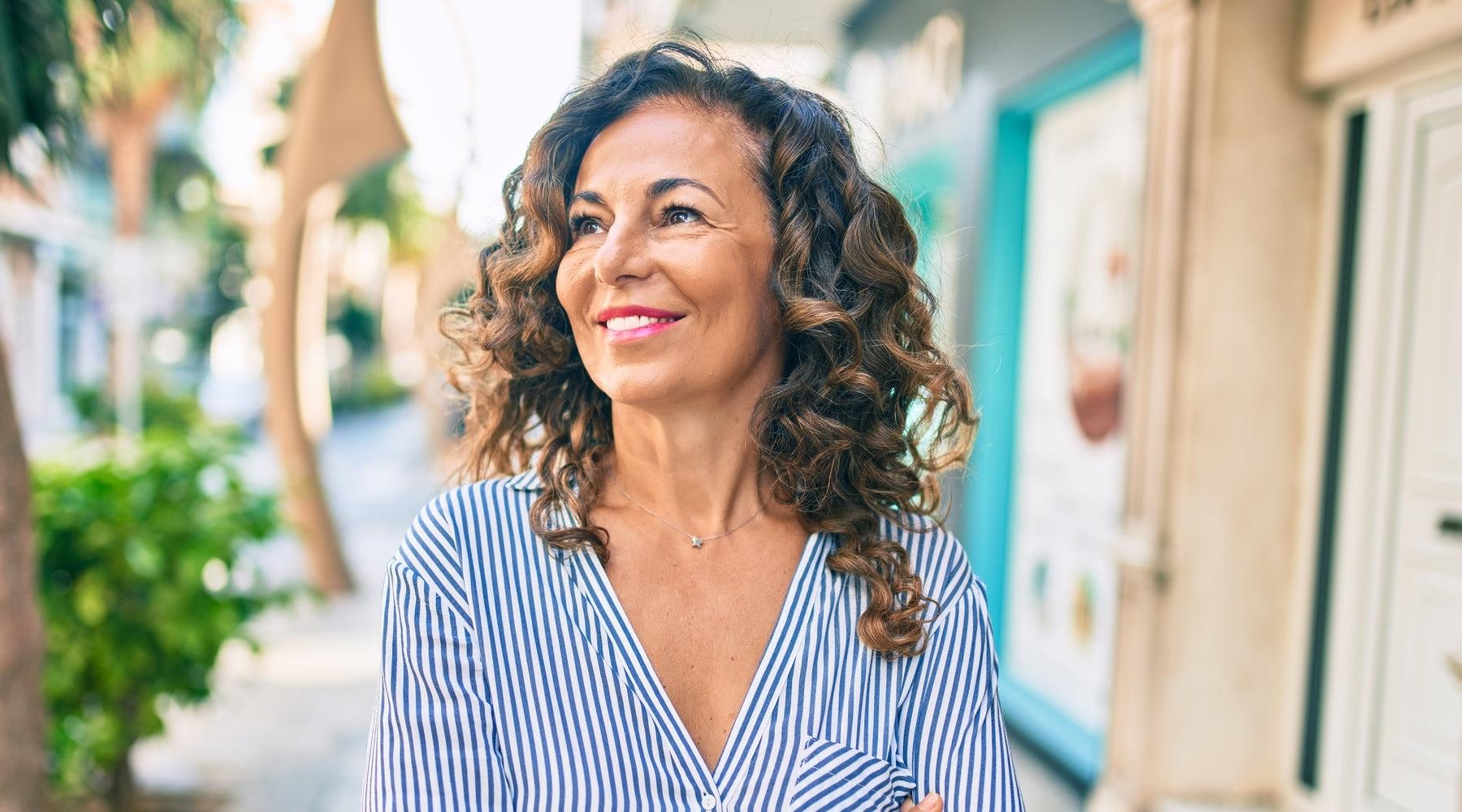 woman smiling and walking down the street