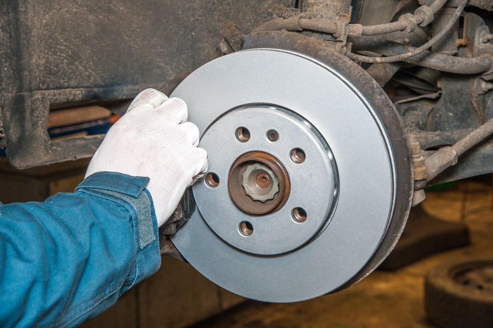 mechanic adjusting assembled disc brakes with brake caliper
