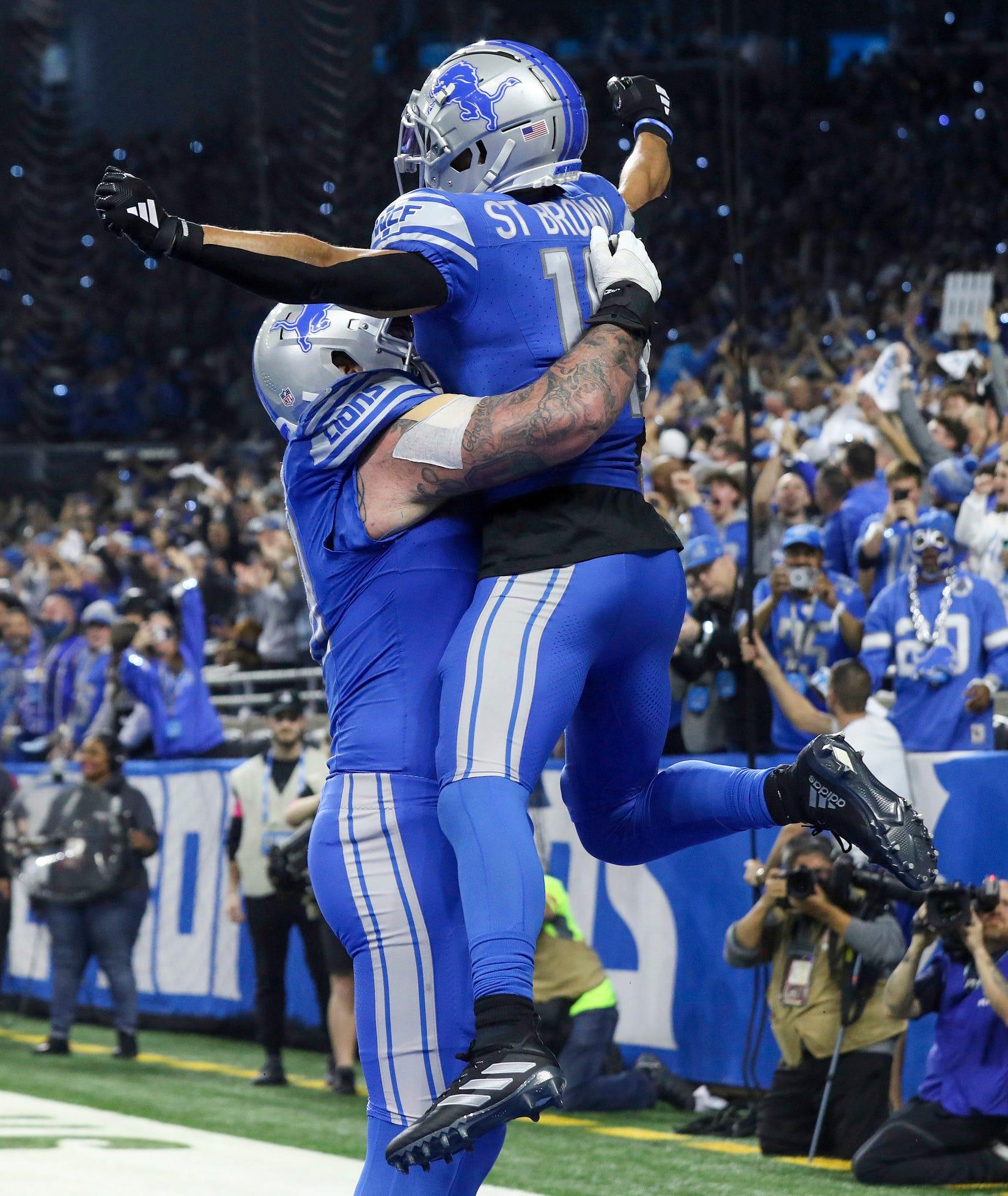 Detroit Lions wide receiver Amon-Ra St. Brown and left tackle Taylor Decker celebrate Brown