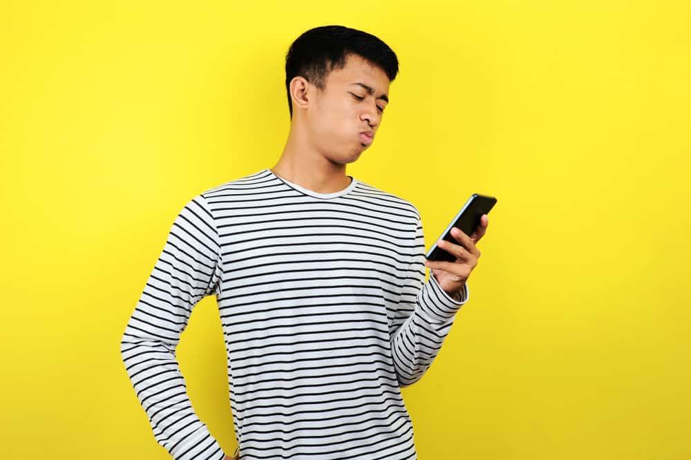confused man looking at smartphone