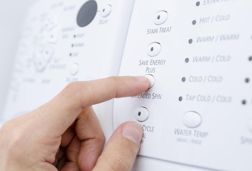 a person choosing the save energy plus option on a washing machine