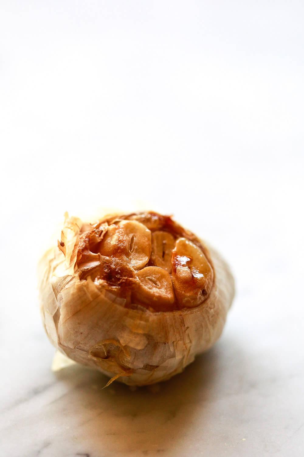 A head of roasted garlic with caramelized garlic cloves.