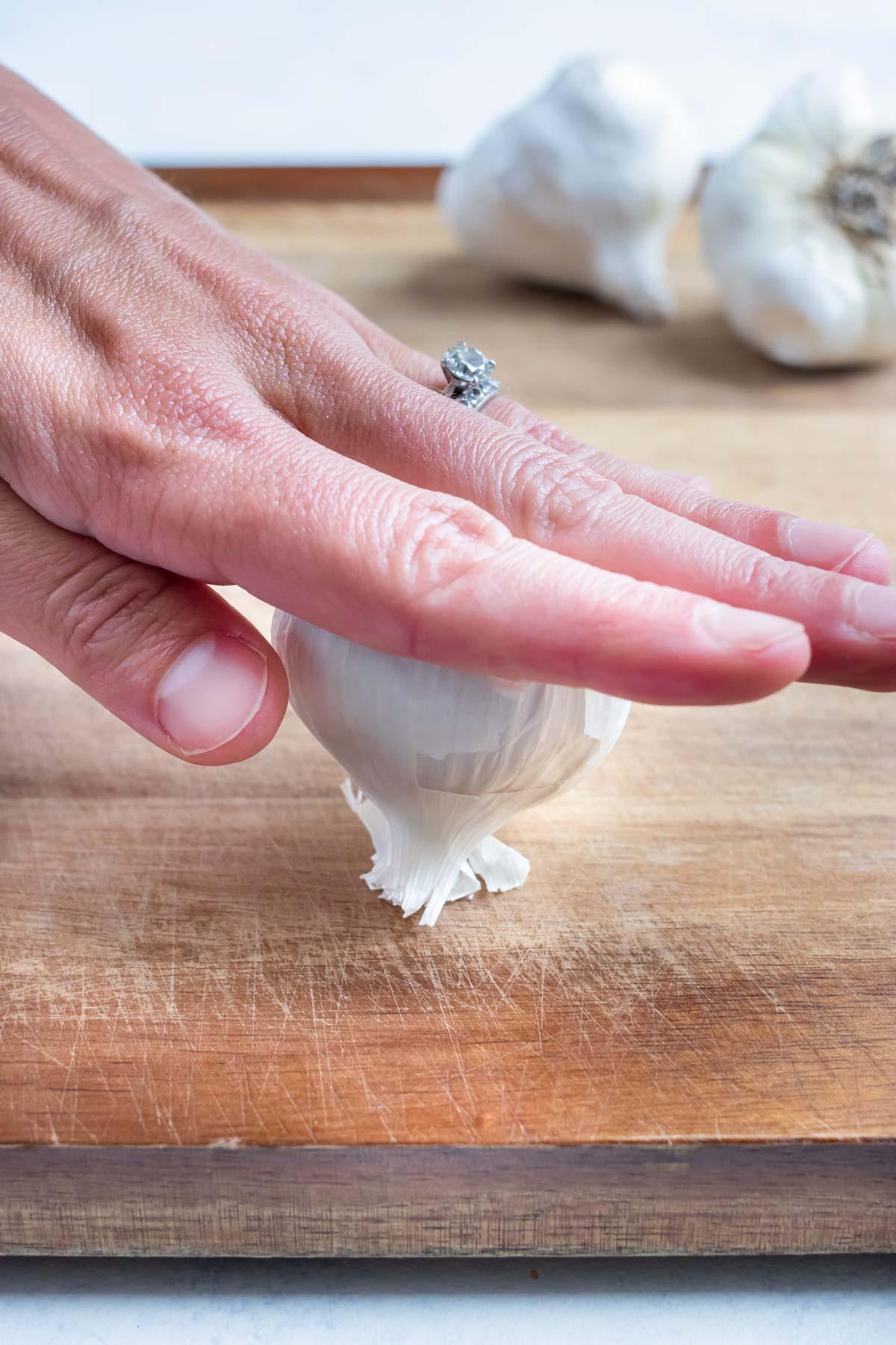 The full garlic bulb is pushed down with your hand.