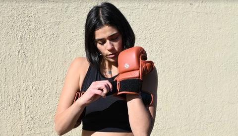 female boxer wearing boxing glove with a velcro closure