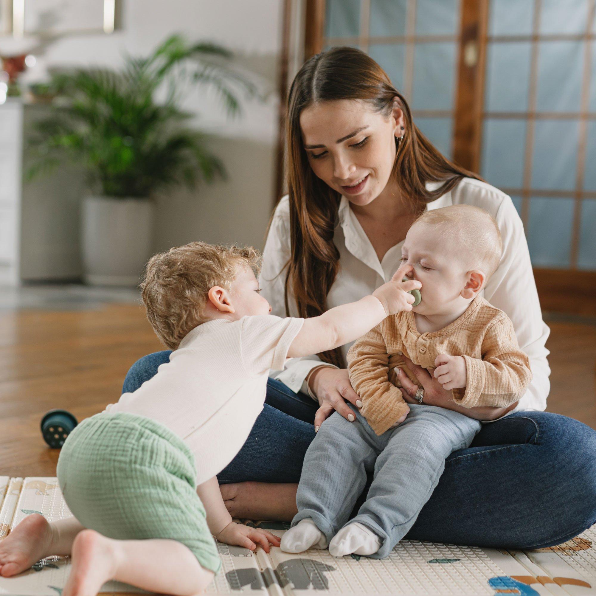 Toddler Playing with Baby on Floor