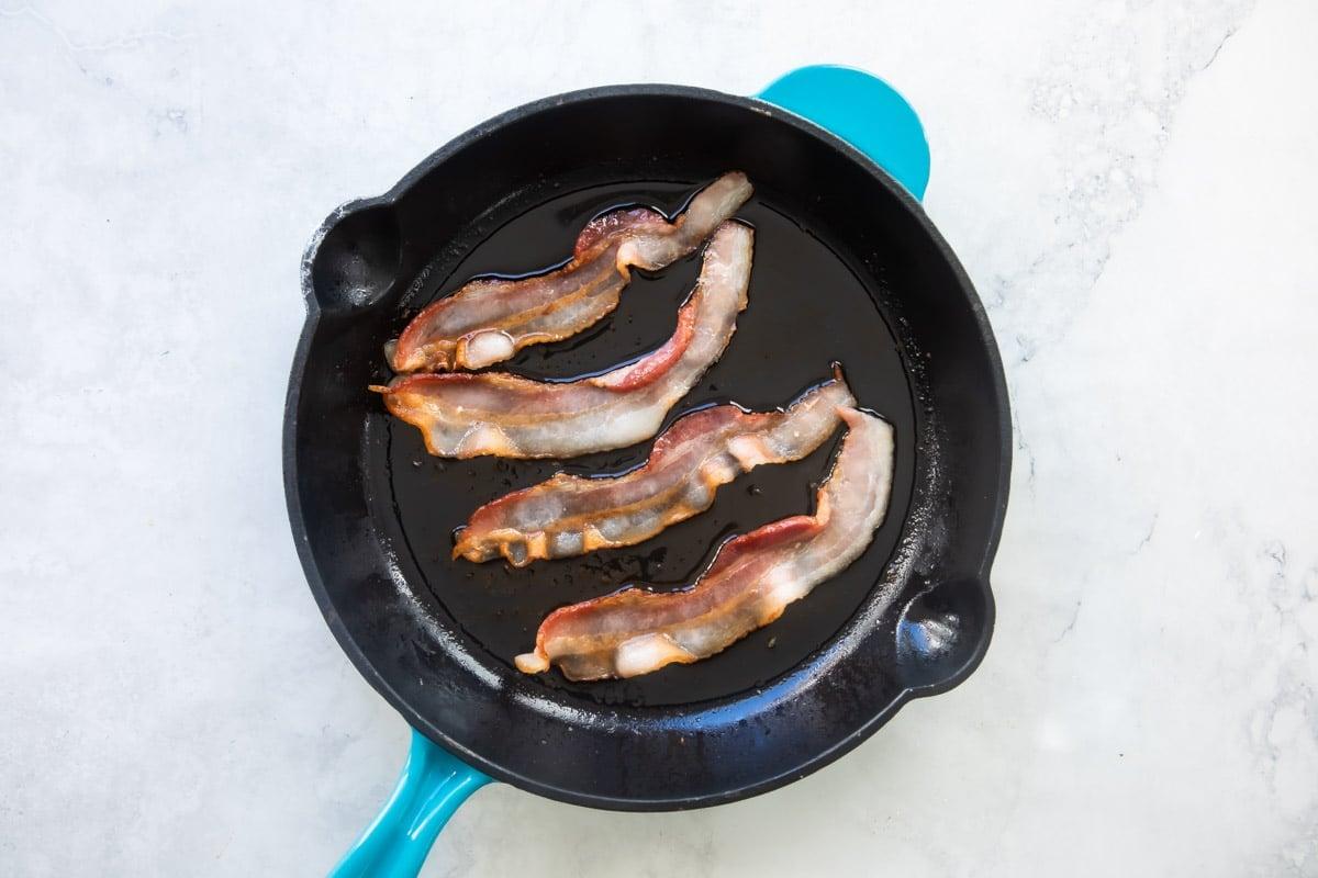 Cooking bacon in a skillet.