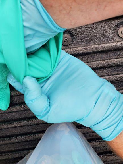 Clean disposable glove removing dirty reusable glove