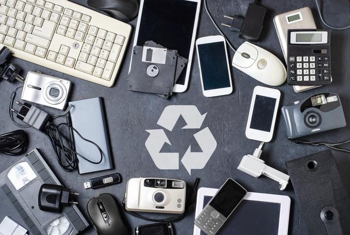 A bunch of electronics is scattered all over: computers, phones, cameras, keyboards, flash drives, etc.