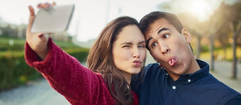 Happy young couple taking funny selfie