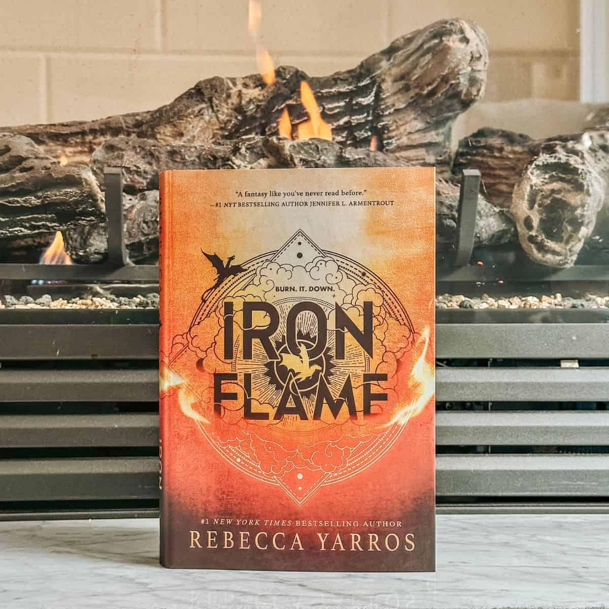 iron flame by rebecca yarros in front of a fireplace.