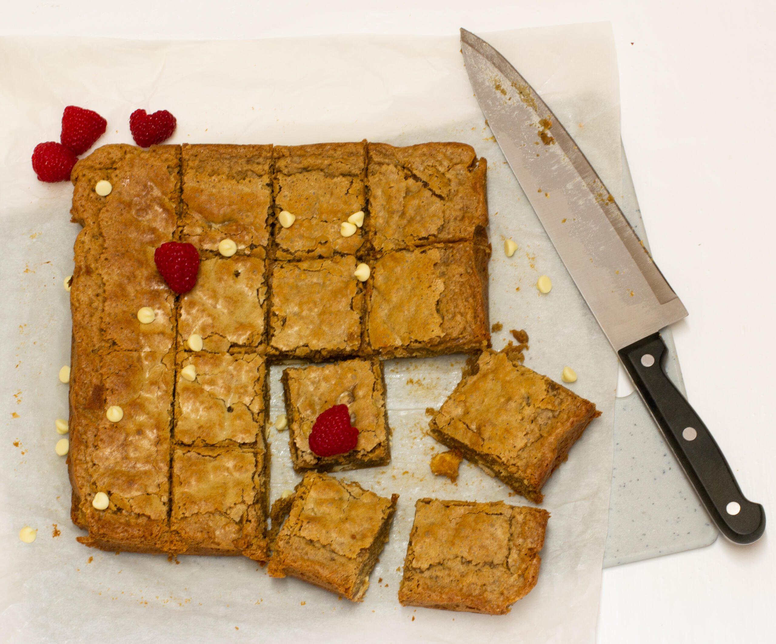 Coffee blondies on a small chopping board with white coffee mug