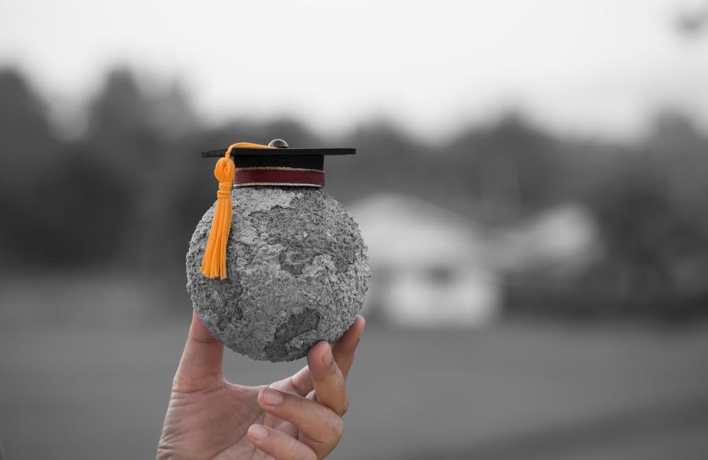Miniature earth made of paper mache with a graduation cap that represents global awareness.