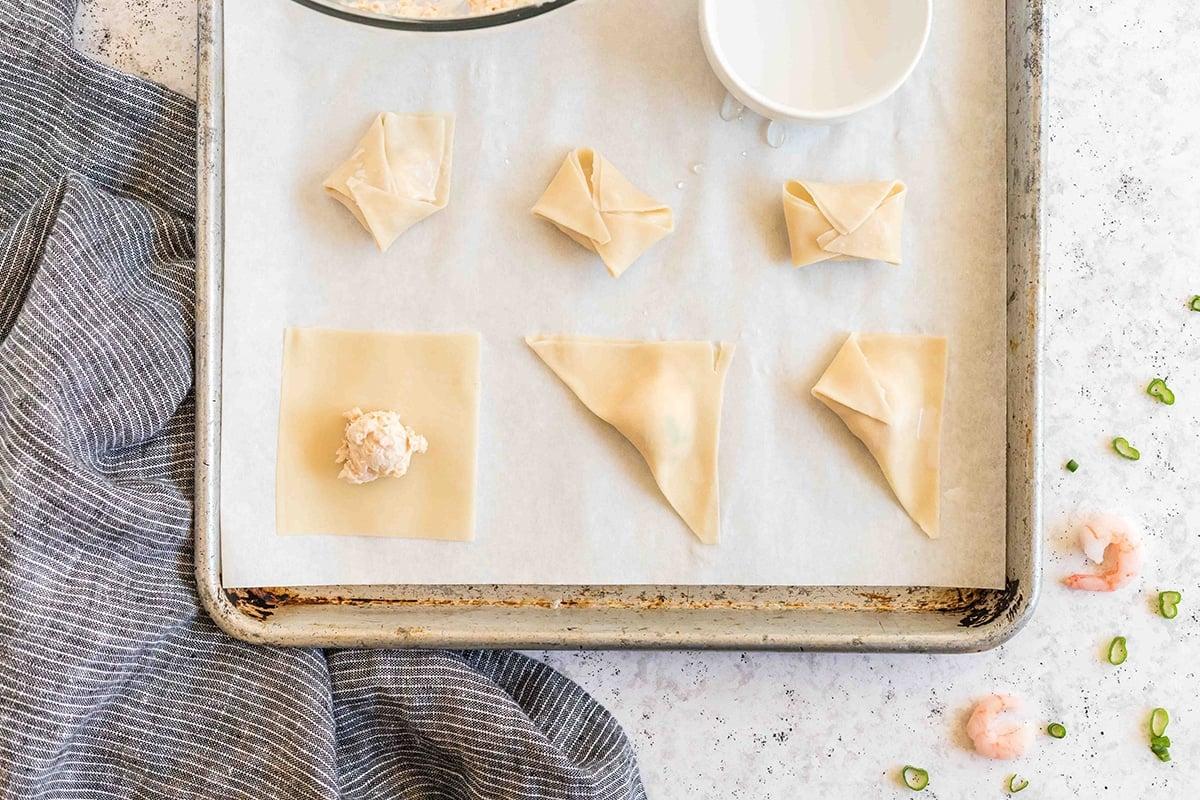 wonton wrappers folded on sheet pan