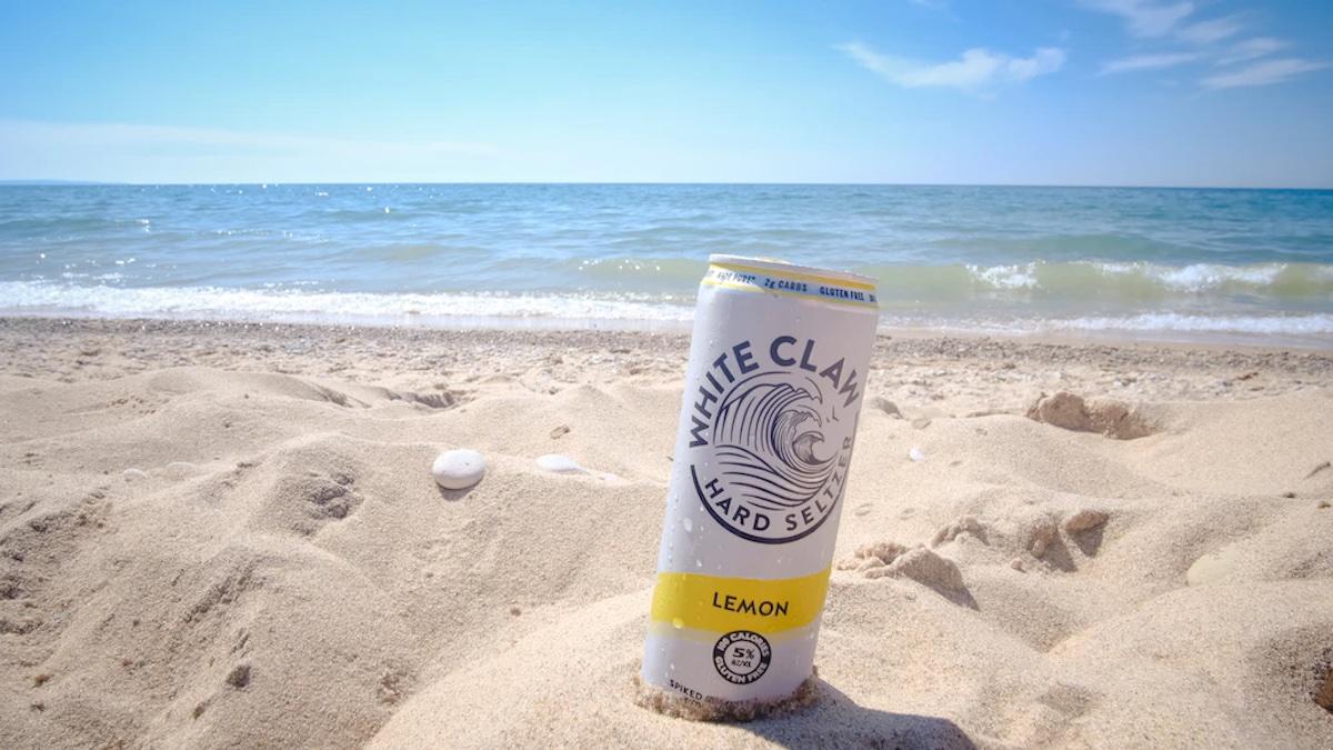 Picture of a white claw can in the sand at the beach.