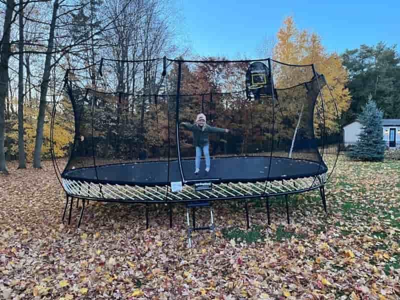 Girl on a Springfree Jumbo Oval Trampoline during the fall
