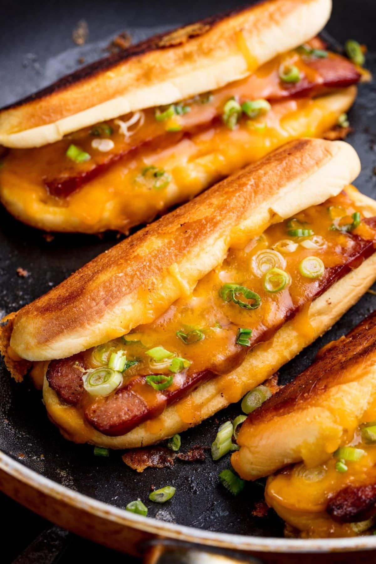 Scrumptious grilled cheese dogs in a pan.