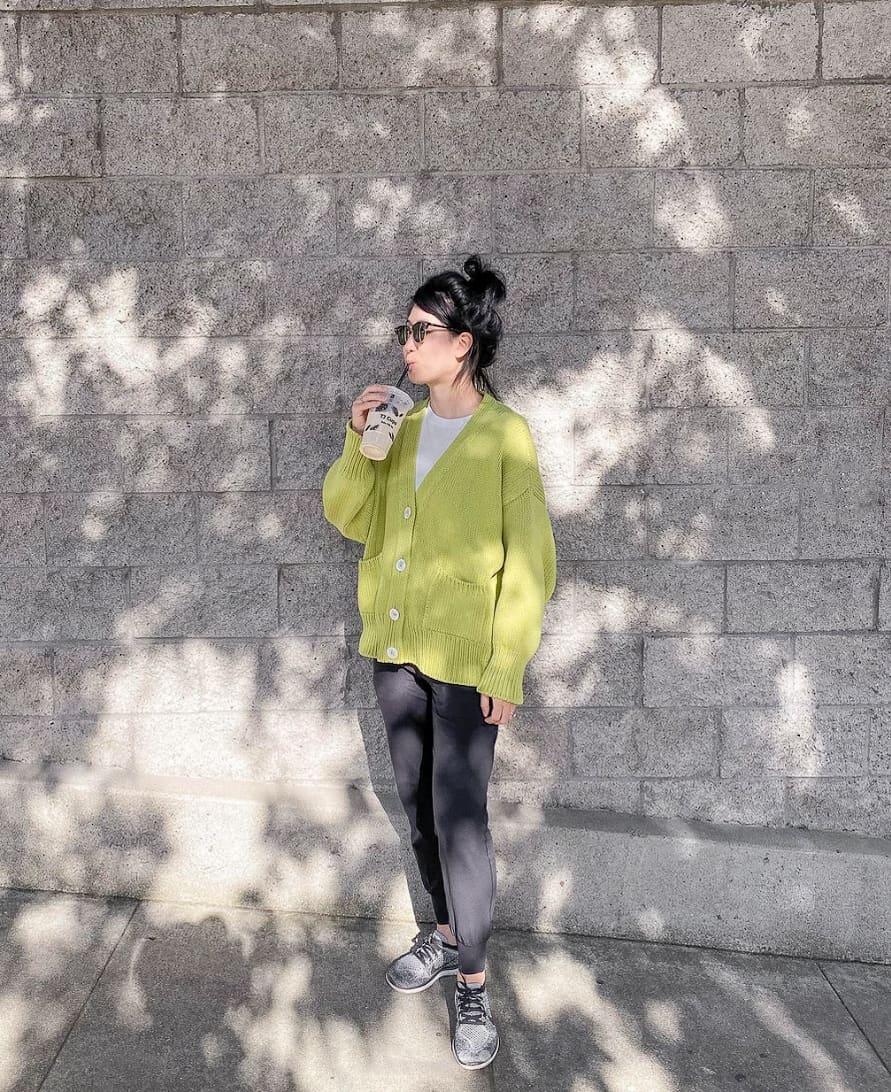 woman wearing a lime green knit cardigan with black joggers and sneakers