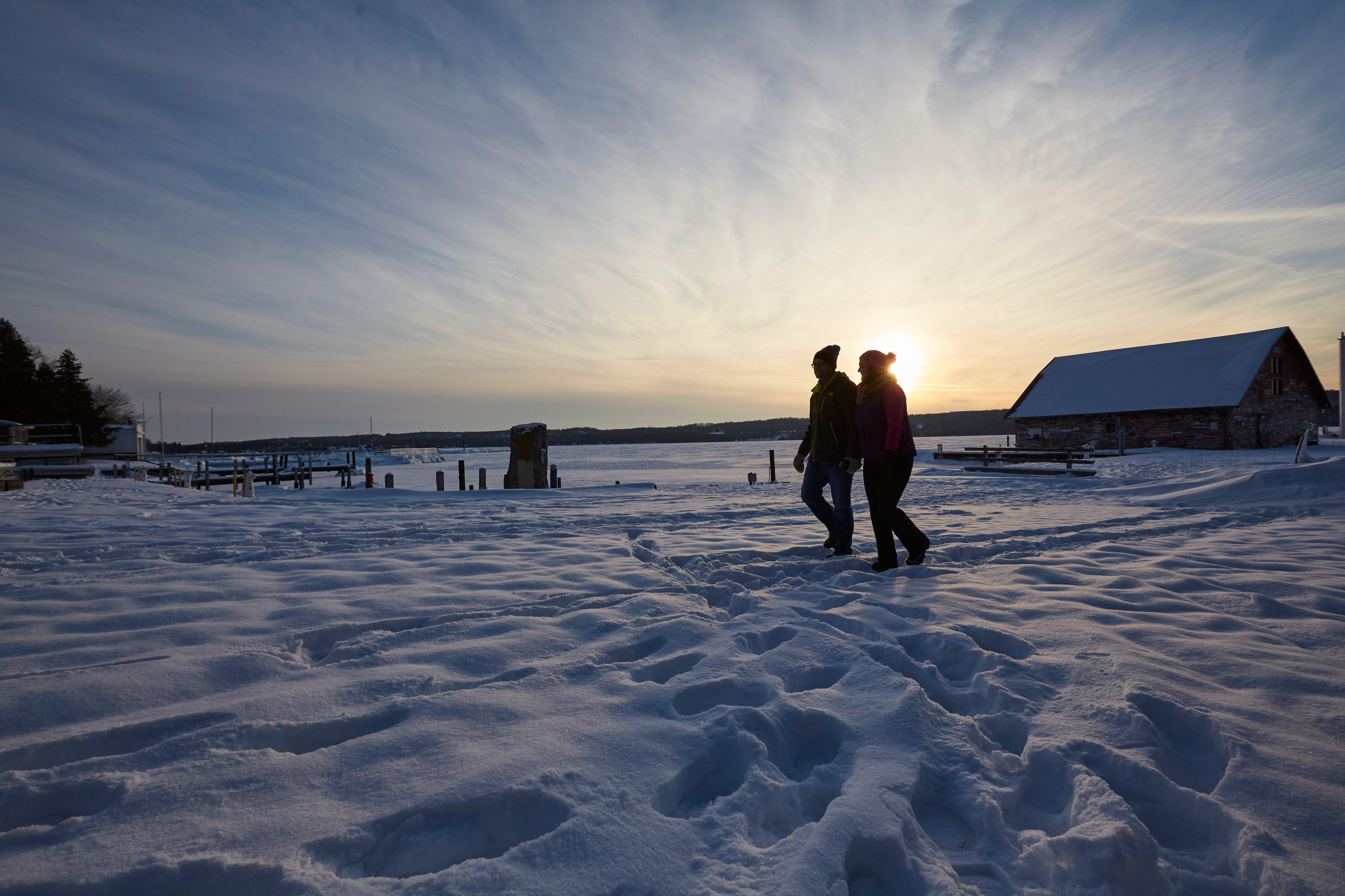 A couple enjoys a winter sunset hike at Anderson Dock in Ephraim, Door County.