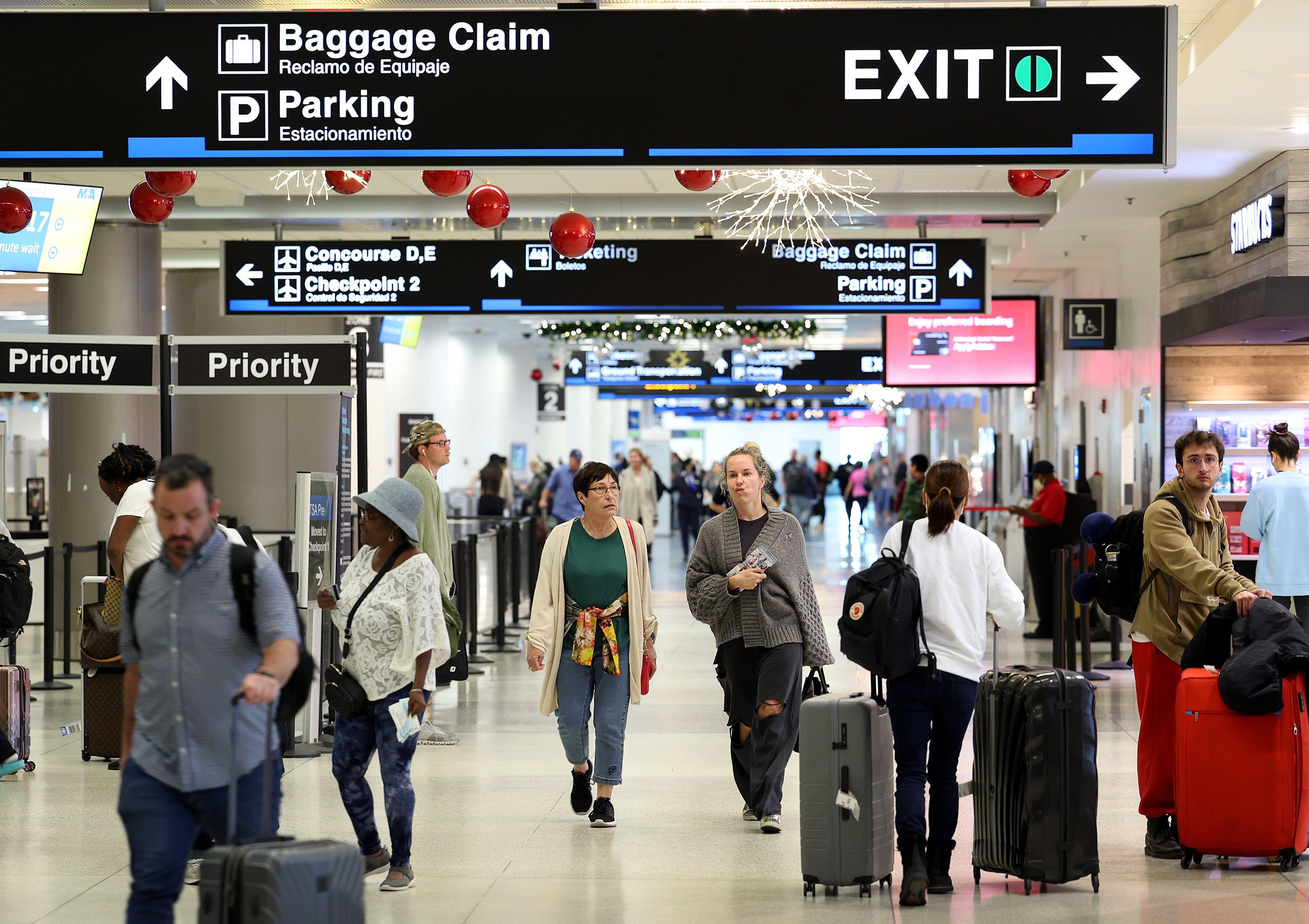 Travelers walk through Miami International Airport on December 19, 2022 in Miami, Florida. (Photo by Joe Raedle/Getty Images)